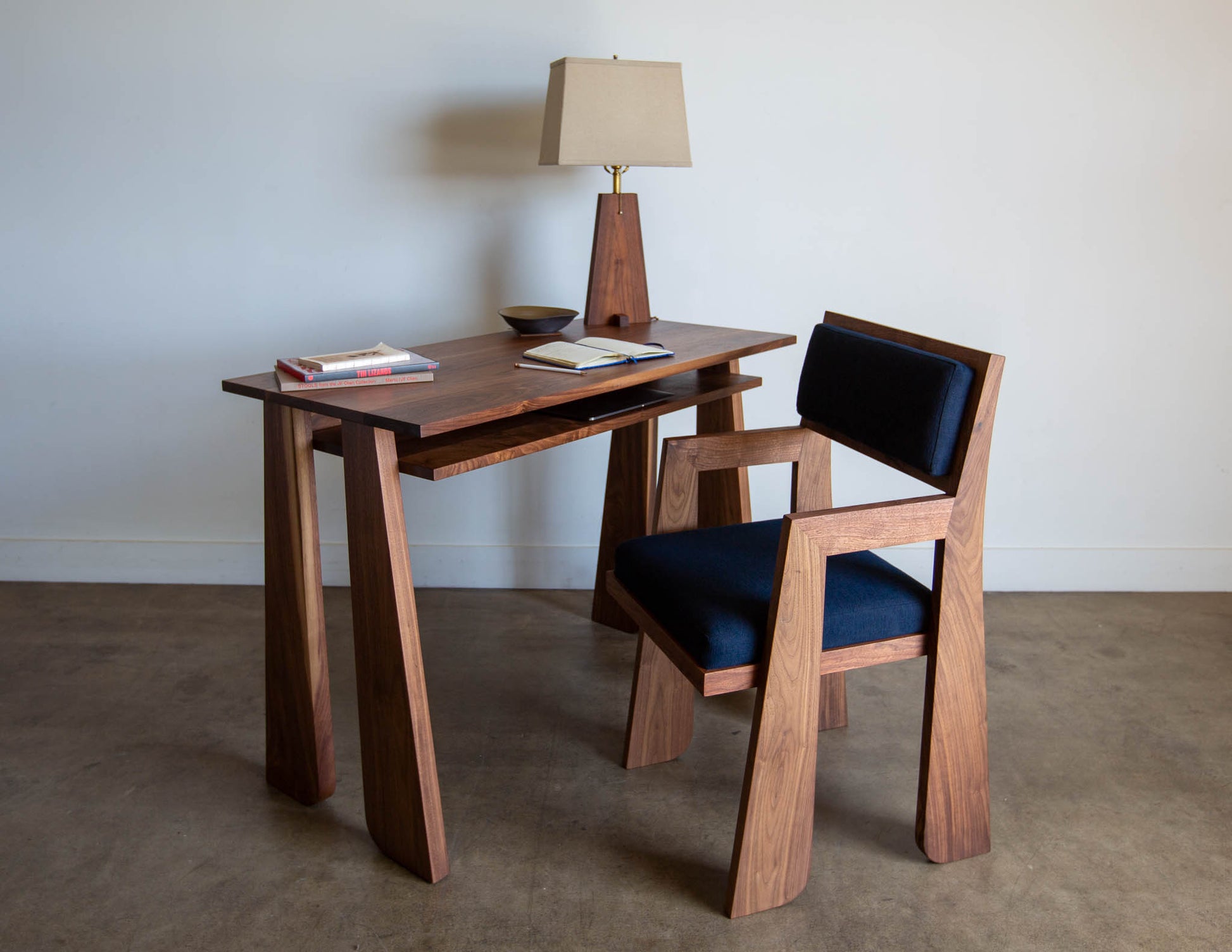 The hand-built Snyder DePass Walnut Temple Desk is shown with a matching Walnut Temple Upholstered Chair, highlighting how the two pieces work together to create a sophisticated and functional home office setup.