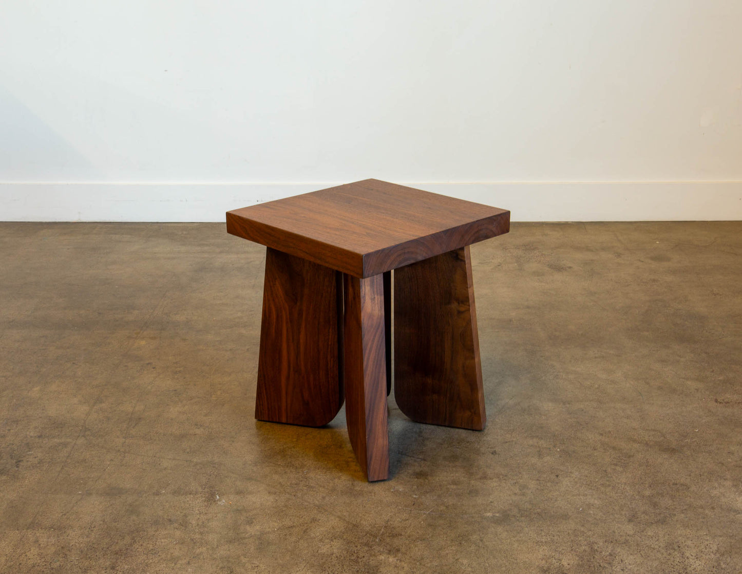 A full view of the hand-built Snyder DePass Temple Stool, showcasing its minimalist, sculptural design and the beautiful grain of the solid wood.