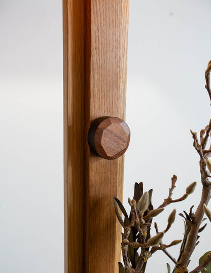 A close-up detail shot of the hand-built Snyder DePass Layered Floor Lamp, focusing on the custom-carved wooden dimmer knob.