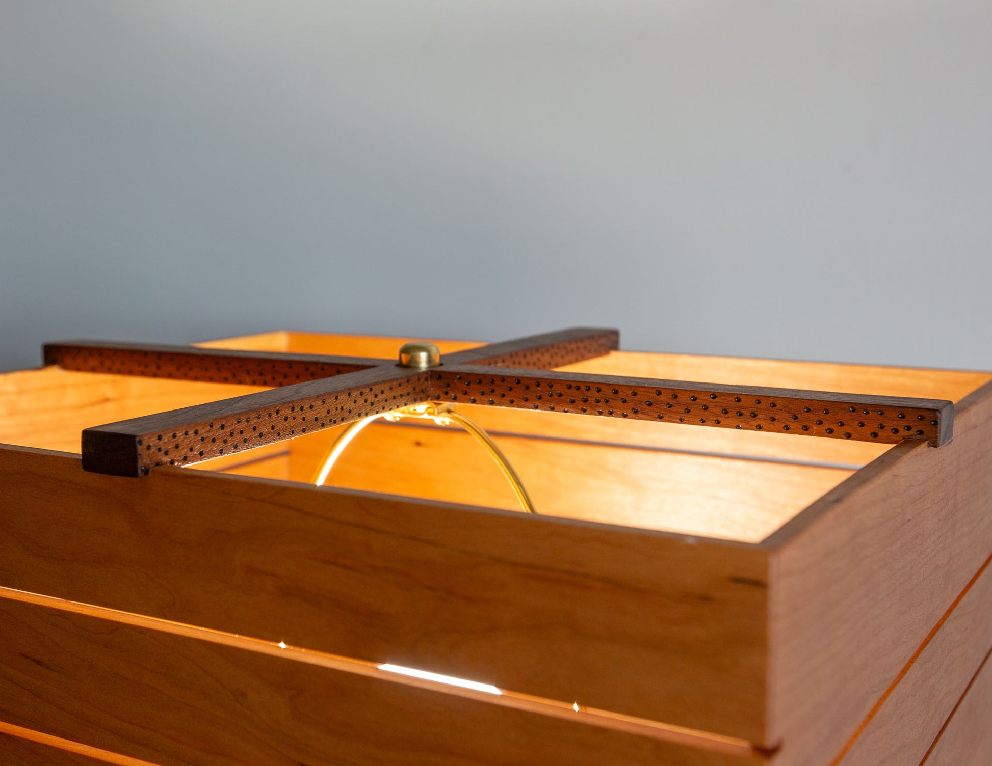 A close-up detail shot of the hand-built Snyder DePass Layered Floor Lamp, focusing on the intricate construction of the layered wood shade and the soft glow it creates.