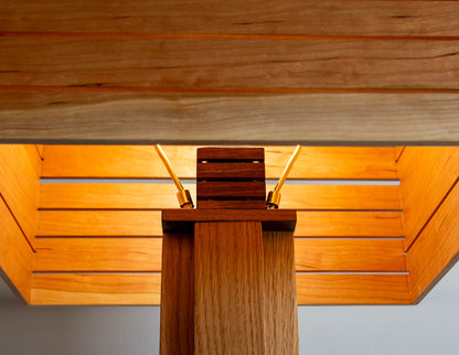 A close-up detail shot of the top of the Snyder DePass Layered Floor Lamp, showing the custom-machined brass socket cover and the seamless wood joinery.