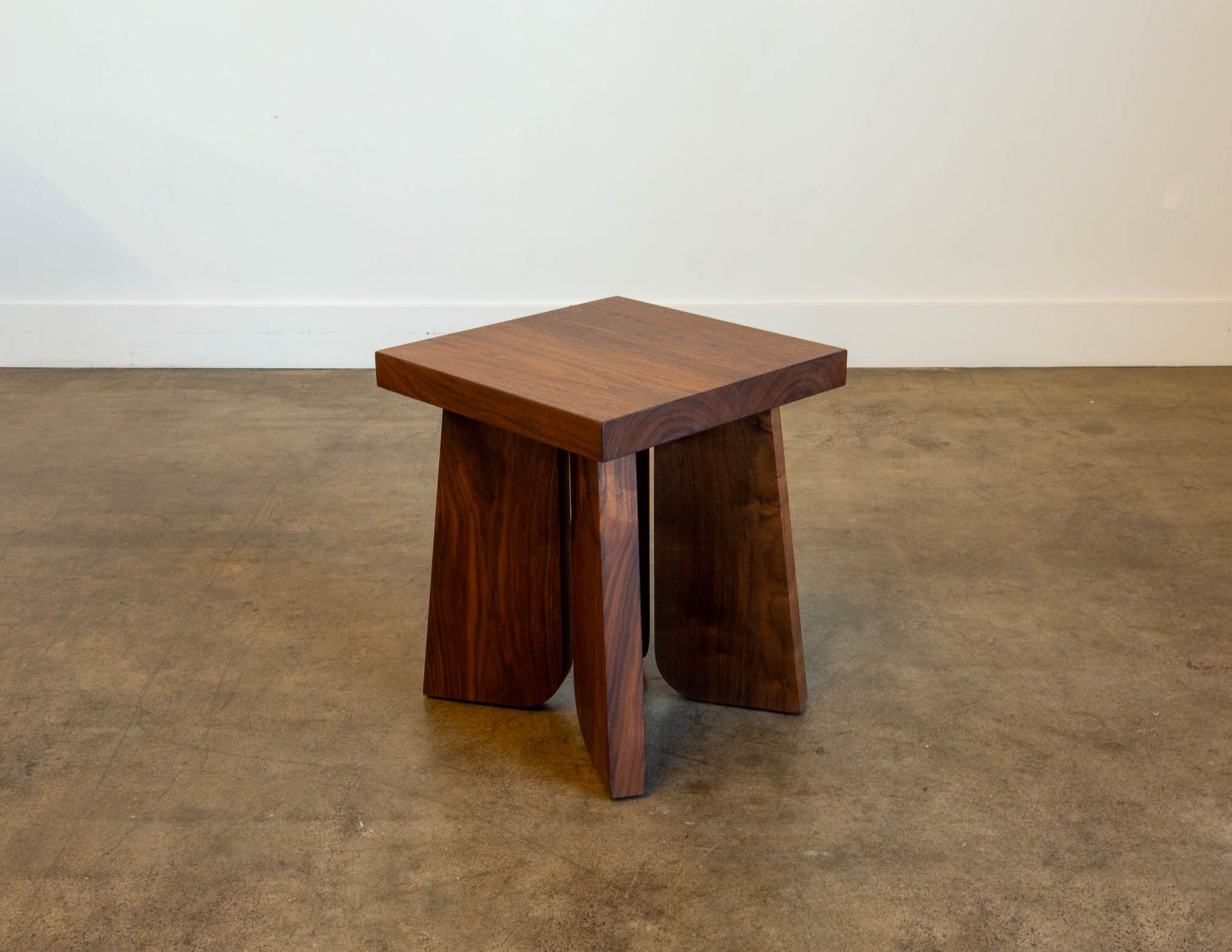 A full view of the hand-built Snyder DePass Temple Stool, showcasing its minimalist, sculptural design and the beautiful grain of the solid wood.
