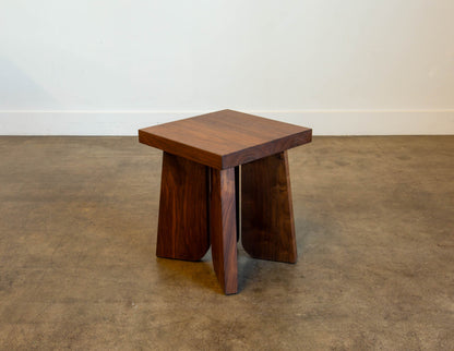 A full view of the hand-built Snyder DePass Temple Stool, showcasing its minimalist, sculptural design and the beautiful grain of the solid wood.