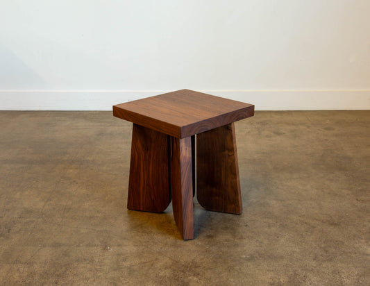 A full view of the hand-built Snyder DePass Temple Stool, showcasing its minimalist, sculptural design and the beautiful grain of the solid wood.